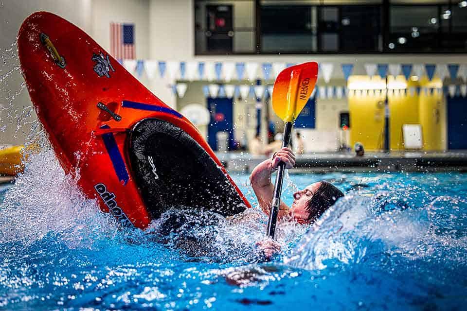 A kayaker nearly flips in their kayak while practicing in a 博彩网址大全 pool